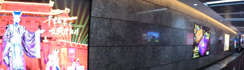 Underpass with panels depicting a show in the city wall